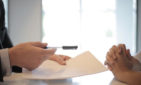 businessman giving contract to woman to sign
